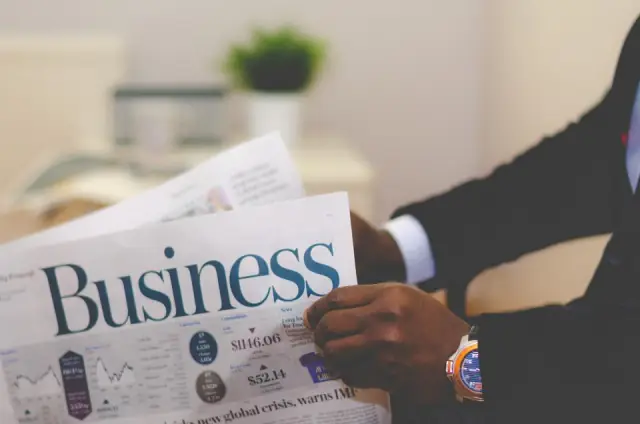 Une personne lit les pages économie d’un journal